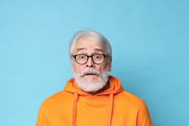 Photo of Senior man with mustache on light blue background