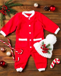 Flat lay composition with cute Christmas baby clothes on wooden background