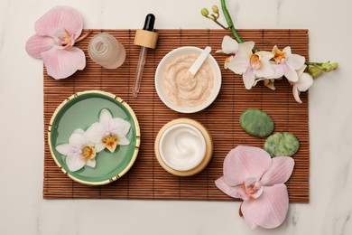 Photo of Composition with different spa products and flowers on white marble table, top view