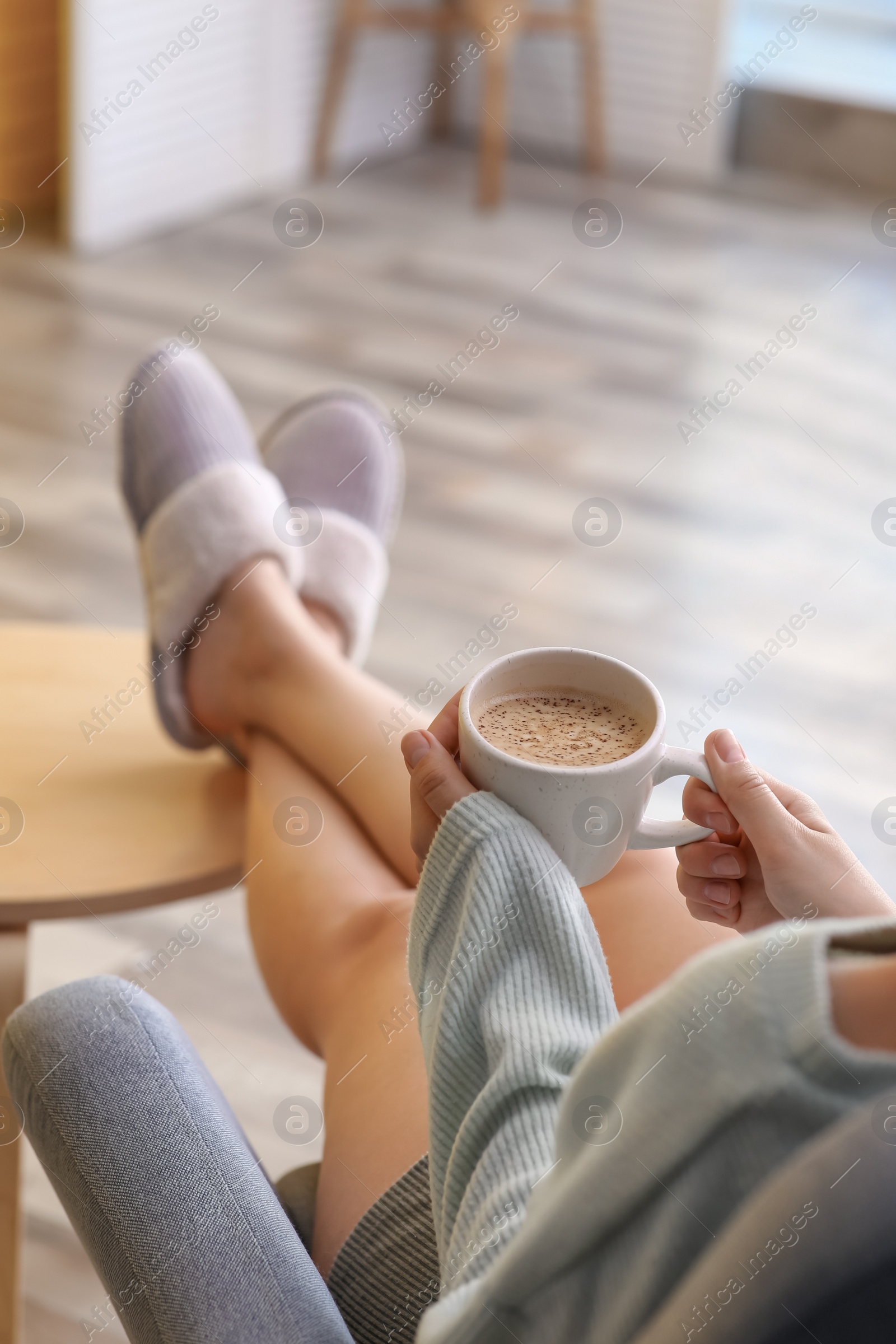 Photo of Woman with cup of aromatic coffee relaxing at home, closeup