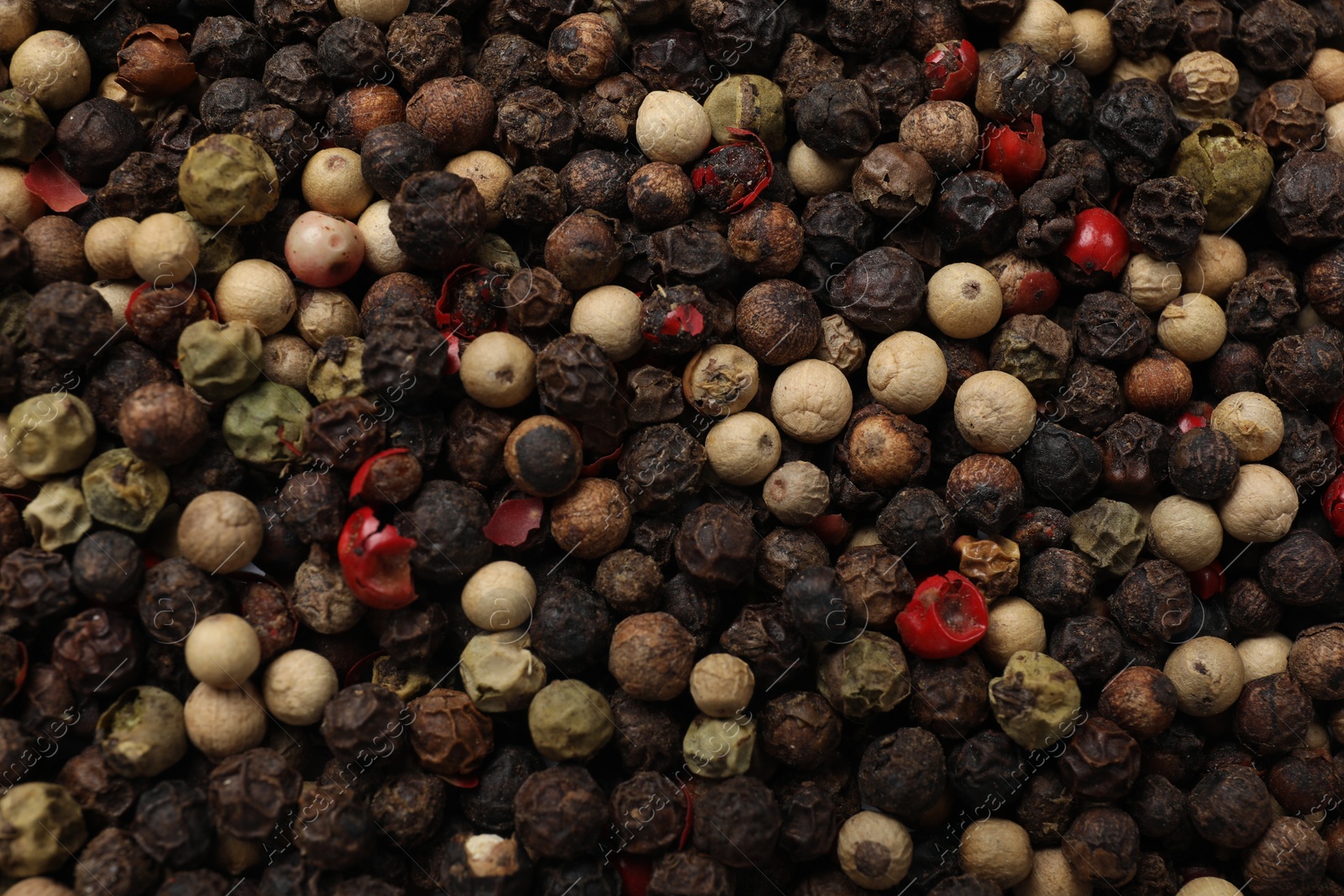 Photo of Aromatic spices. Different peppers as background, top view