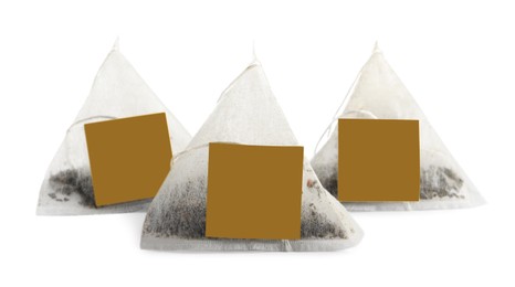 Photo of New pyramid tea bags on white background