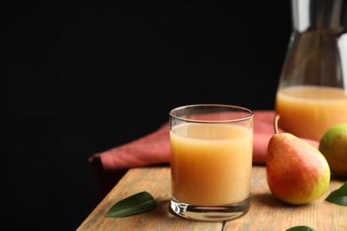 Photo of Fresh pear juice in glass and fruits on wooden table. Space for text