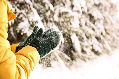 Photo of Woman playing with snow outdoors, closeup. Winter vacation