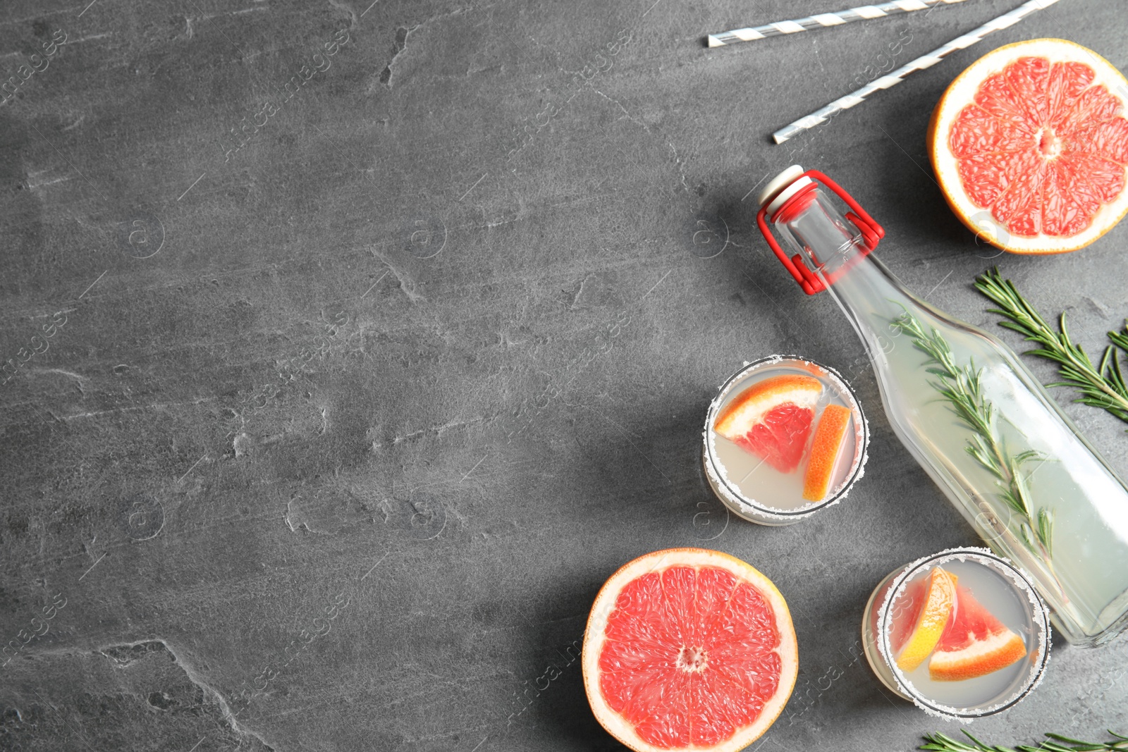 Photo of Flat lay composition with cocktails, grapefruits and space for text on grey table