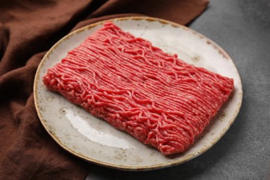 Photo of Fresh raw ground meat on brown textured table, closeup