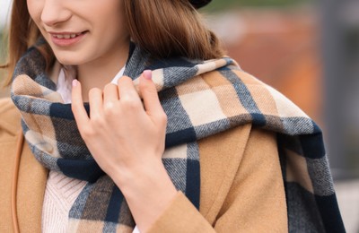 Beautiful woman in warm scarf outdoors, closeup