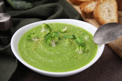 Delicious broccoli cream soup served on grey table, closeup