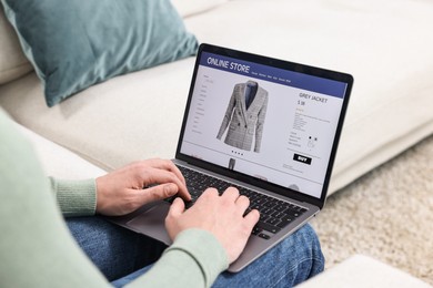 Photo of Man with laptop shopping online indoors, closeup