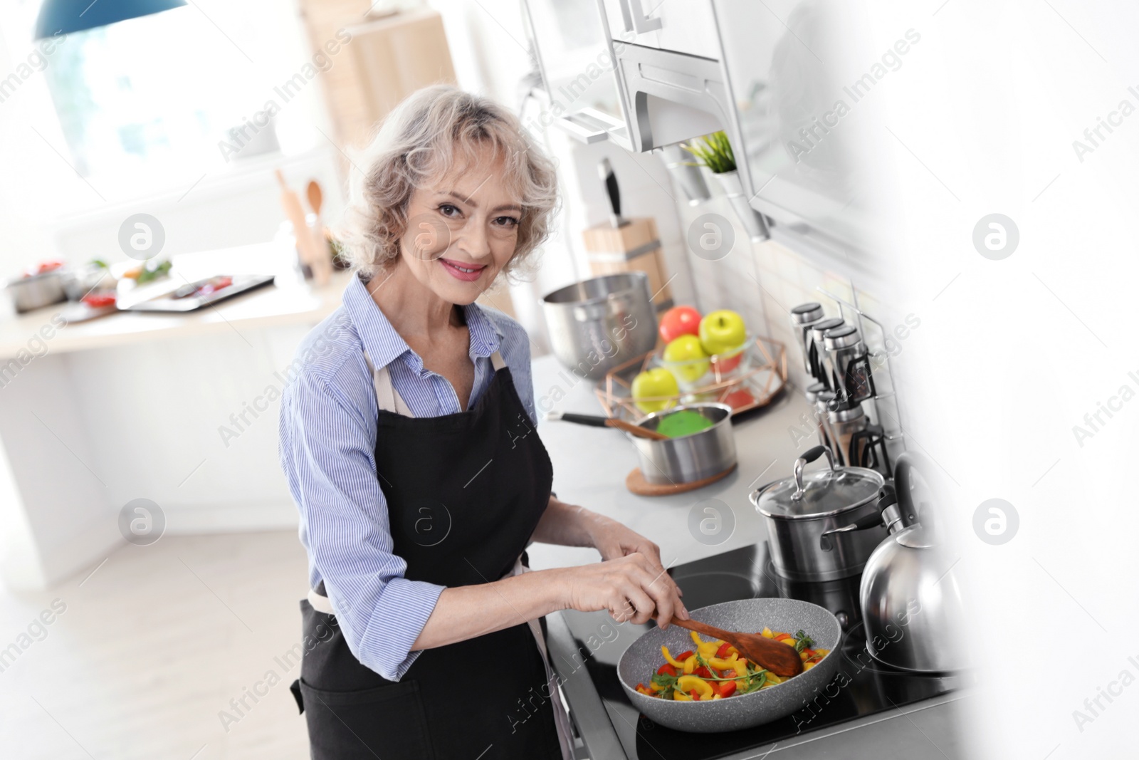 Photo of Professional female chef cooking vegetables in kitchen