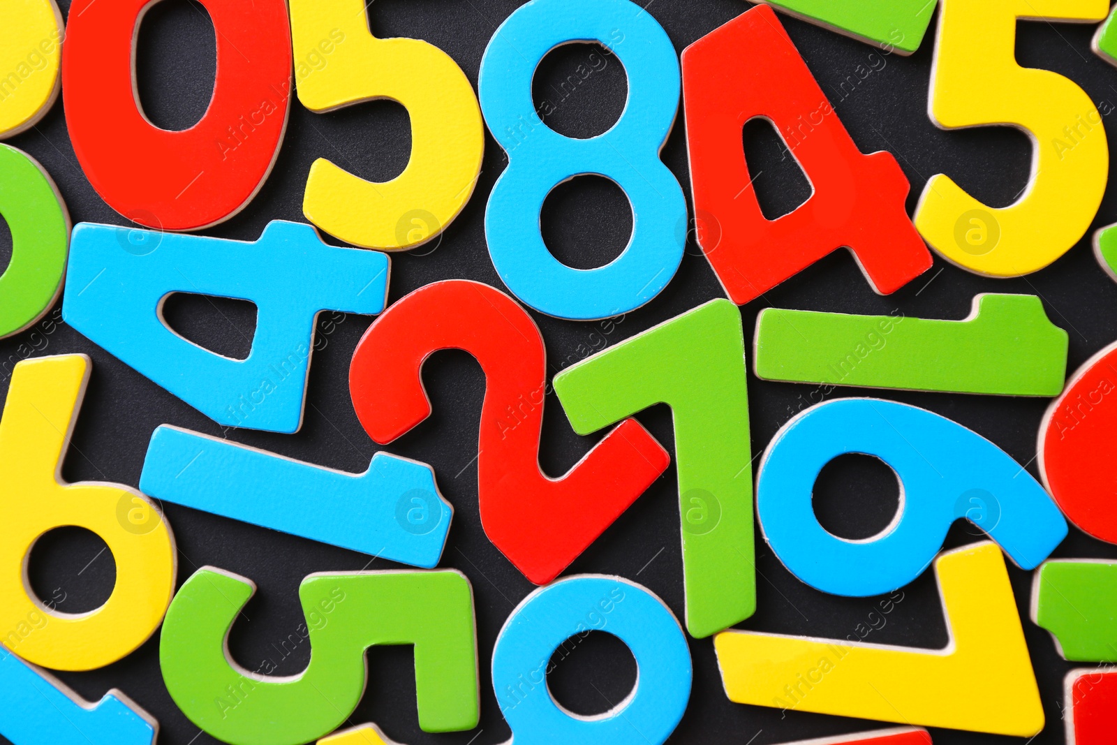 Photo of Colorful numbers on black background, top view