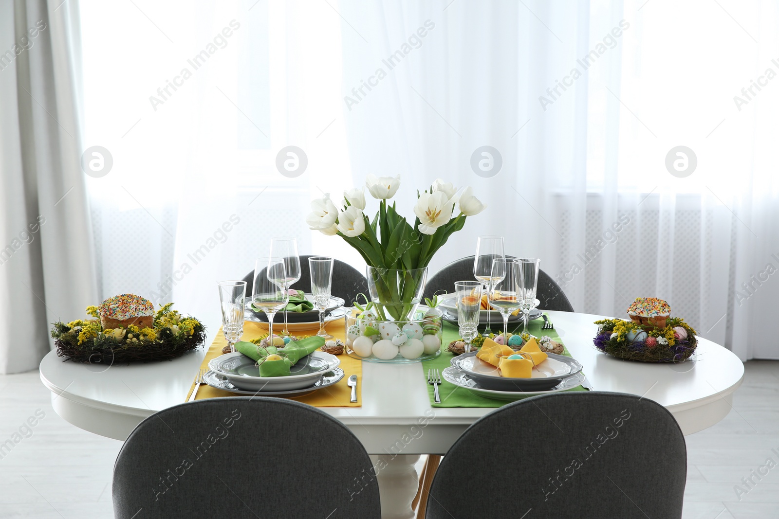 Photo of Festive Easter table setting with beautiful white tulips and eggs indoors