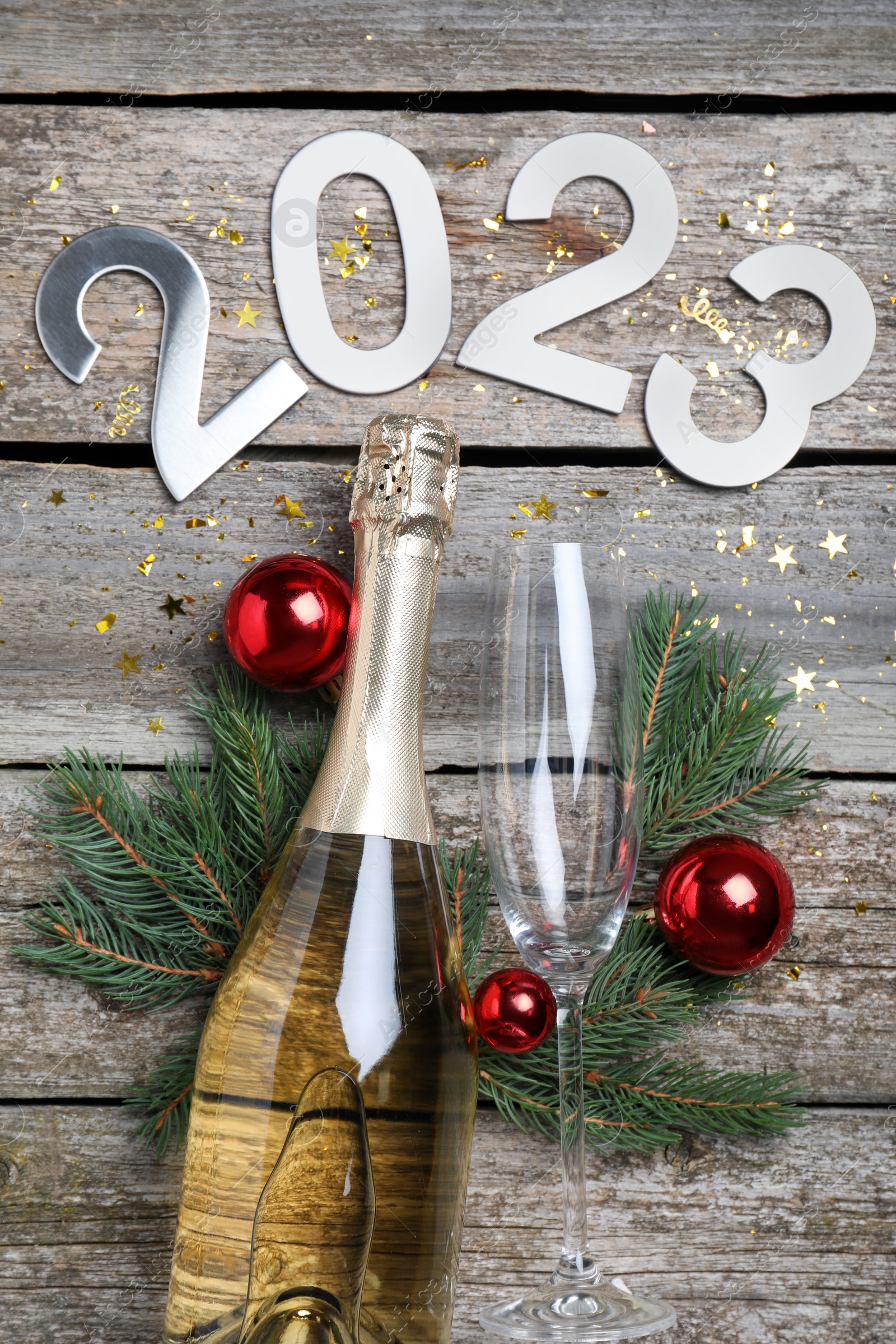 Photo of Happy New Year 2023! Flat lay composition with bottle of sparkling wine on wooden table