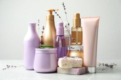 Photo of Composition with hair care cosmetic products on light grey marble table