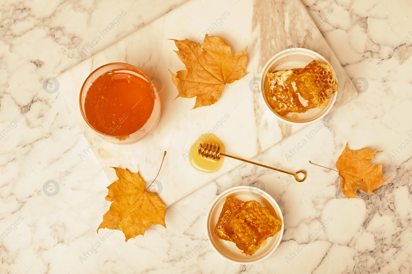 Photo of Flat lay composition with honey and combs on marble background