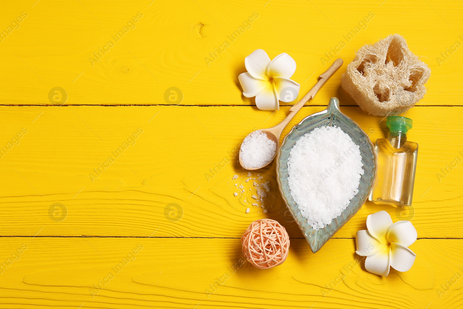 Photo of Flat lay composition with natural sea salt on yellow wooden table. Space for text