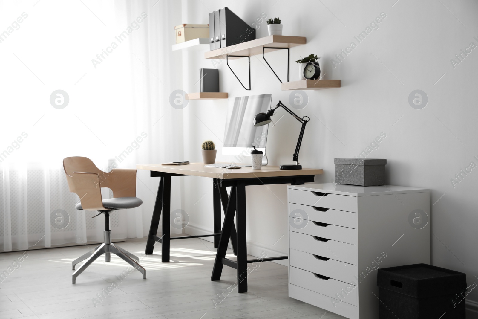 Photo of Comfortable office chair near table with modern computer