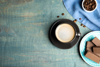 Photo of Breakfast with delicious wafers and coffee on light blue wooden table, flat lay. Space for text