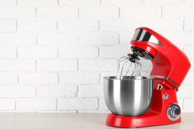 Photo of Modern red stand mixer on white wooden table, space for text