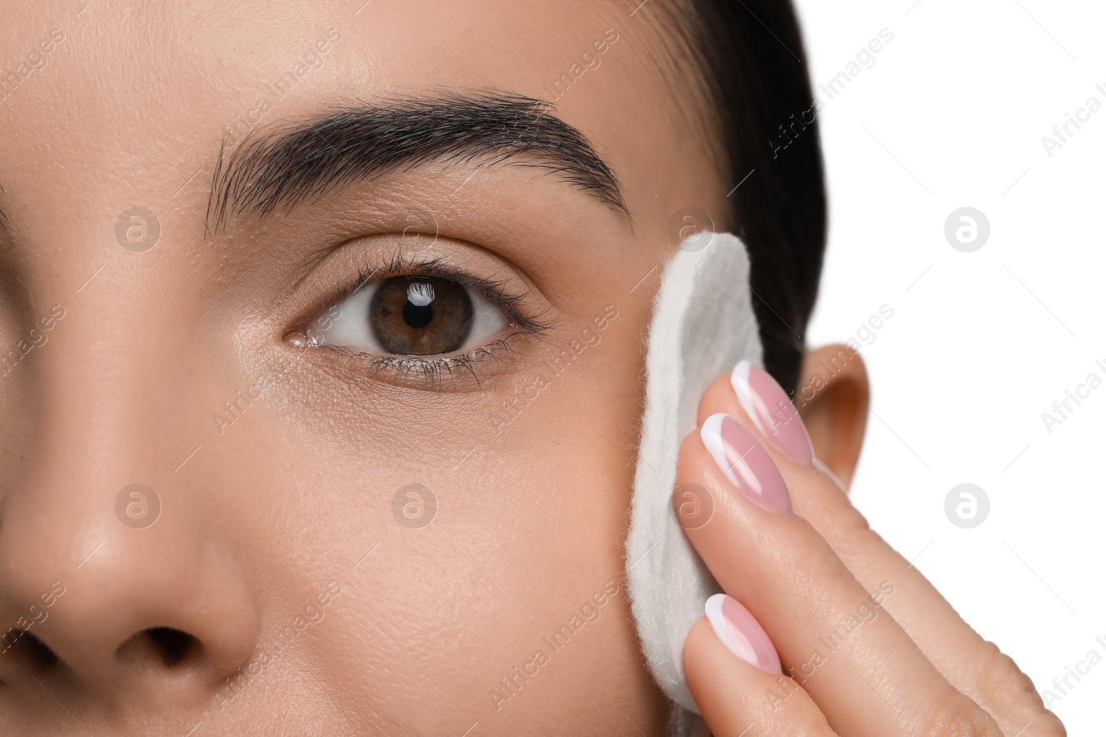 Photo of Beautiful woman removing makeup with cotton pad on white background, closeup