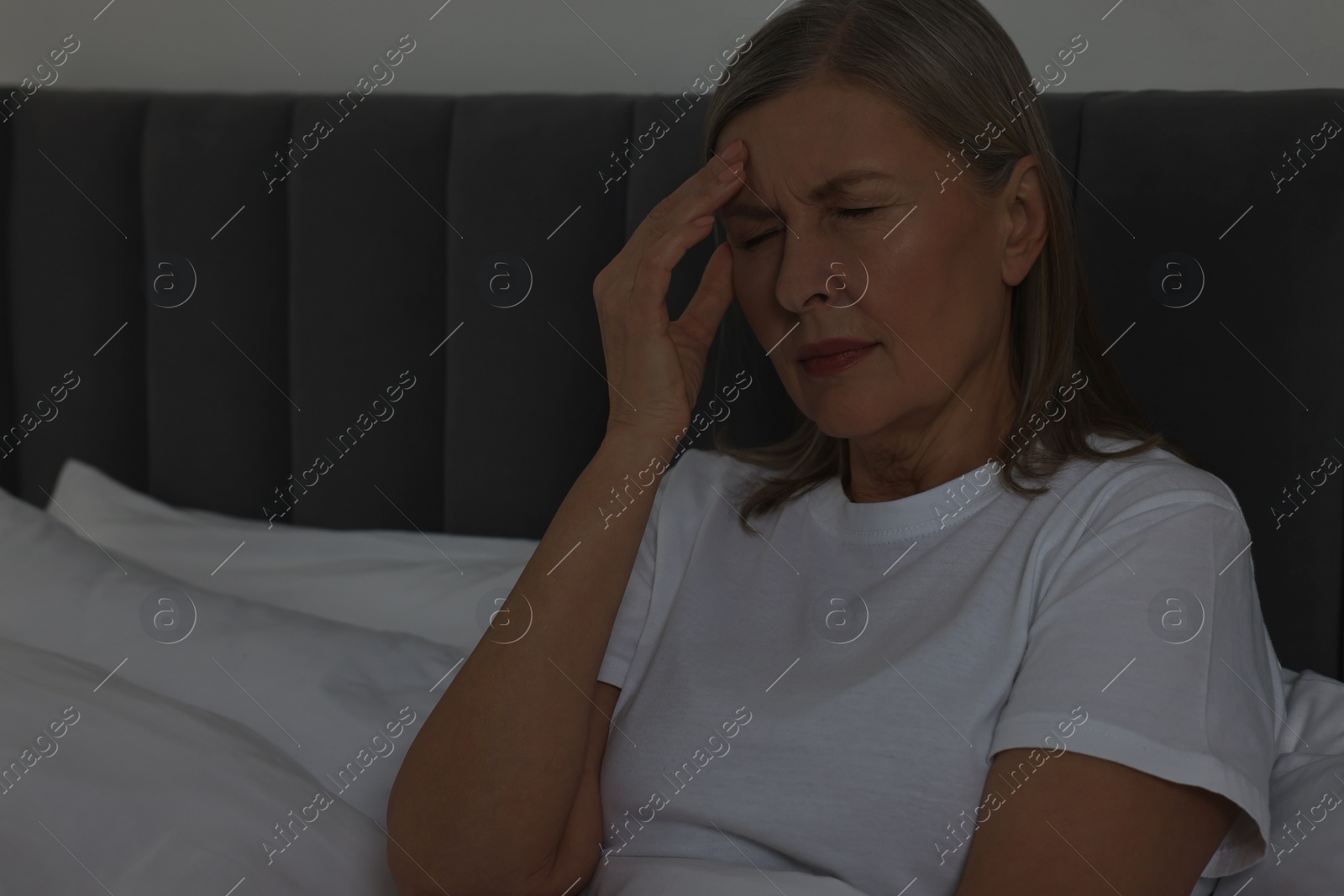 Photo of Woman suffering from headache in bed at night