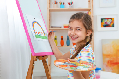 Photo of Cute little child painting during lesson in room