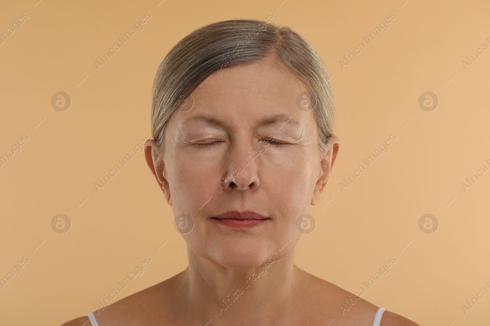 Photo of Woman with closed eyes on beige background