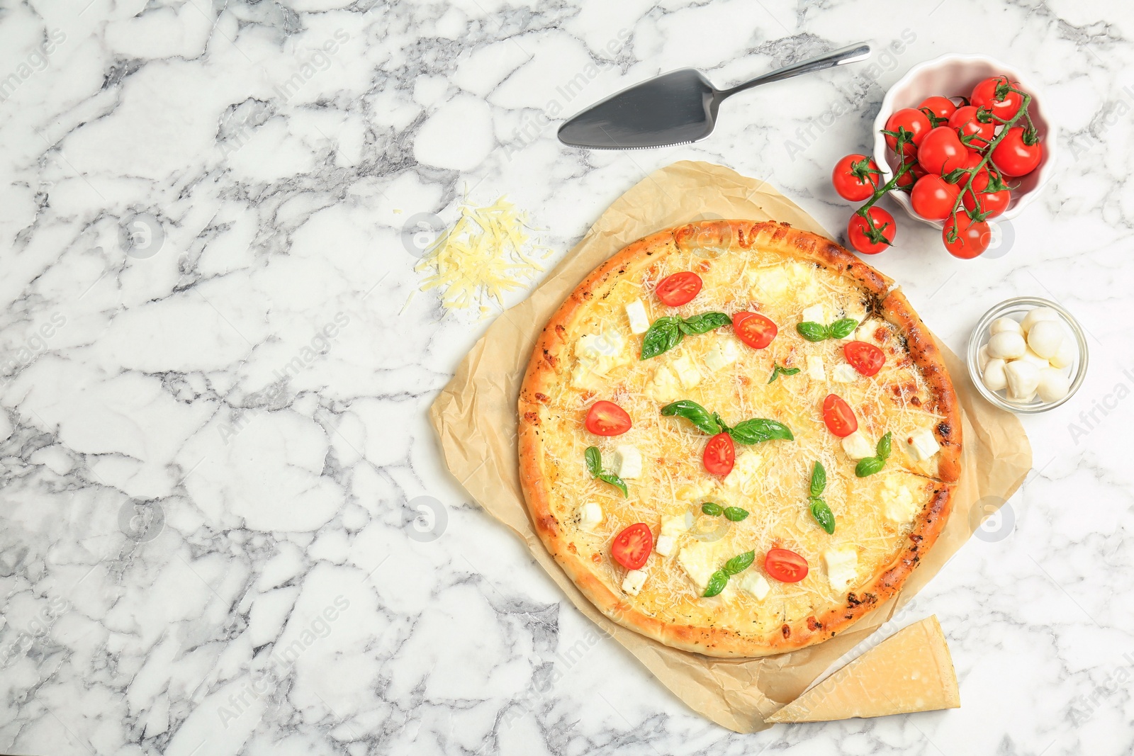 Photo of Delicious pizza with cheese, basil and tomatoes on marble table, top view