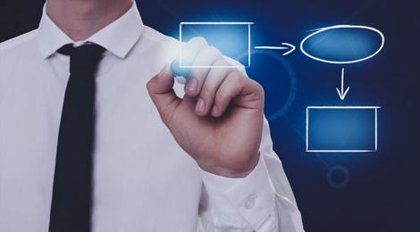Man pointing at flowchart on virtual screen against dark blue background, closeup. Business process