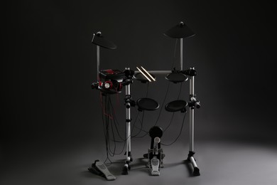 Photo of Modern electronic drum kit on dark background. Musical instrument