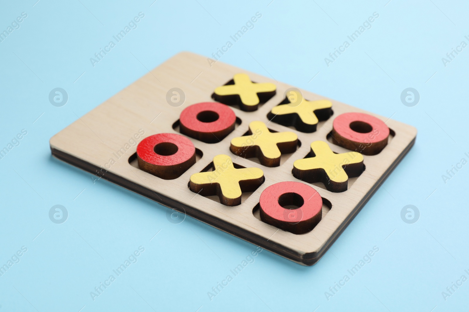 Photo of Tic tac toe set on light blue background