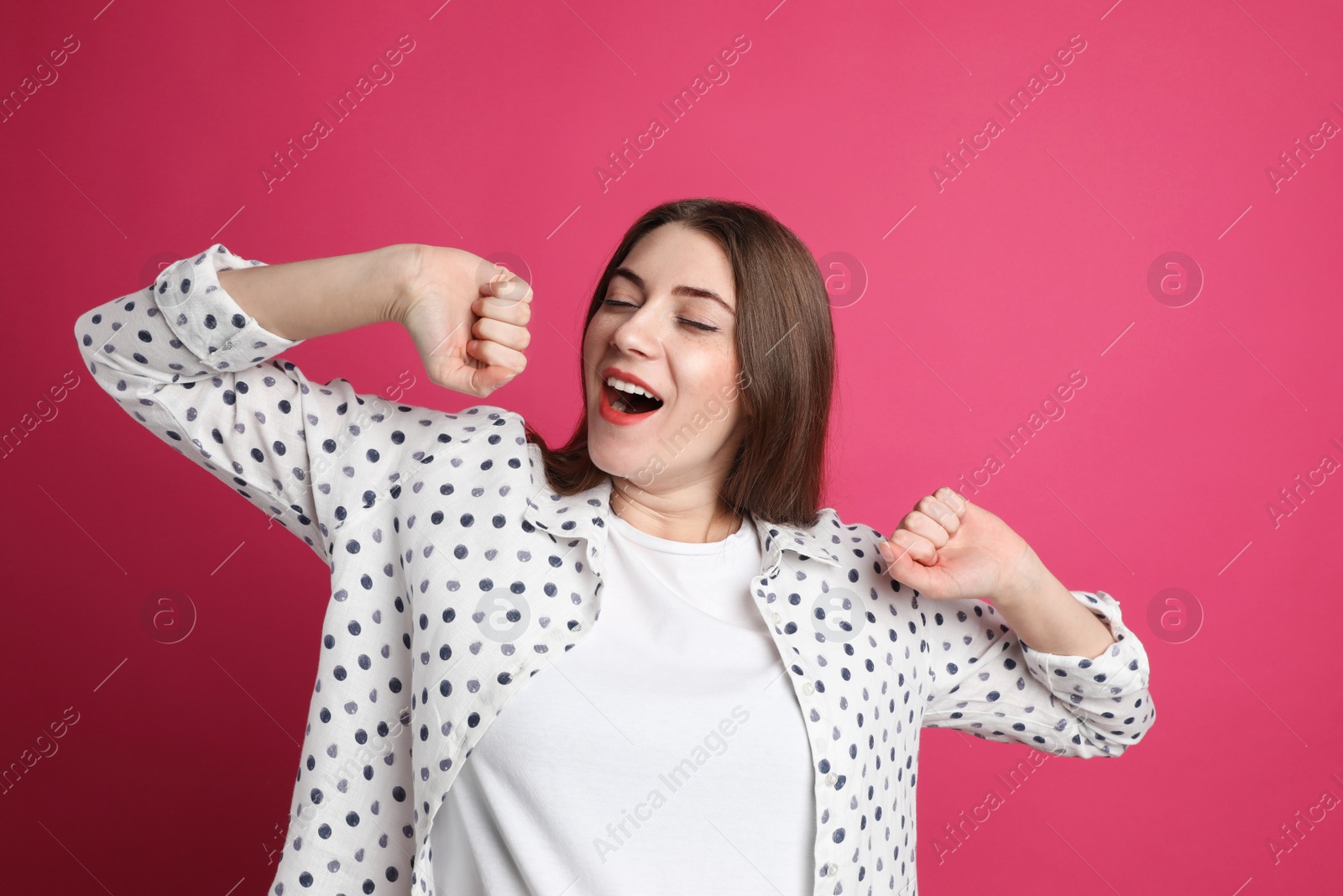 Photo of Young tired woman yawning on pink background