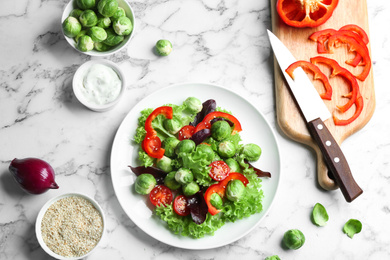 Tasty salad with Brussels sprouts and ingredients on white marble table, flat lay