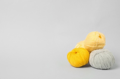 Soft woolen yarns on white background, space for text