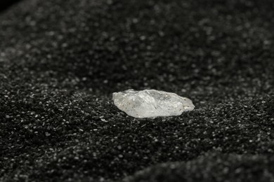 Shiny rough diamond on decorative black sand
