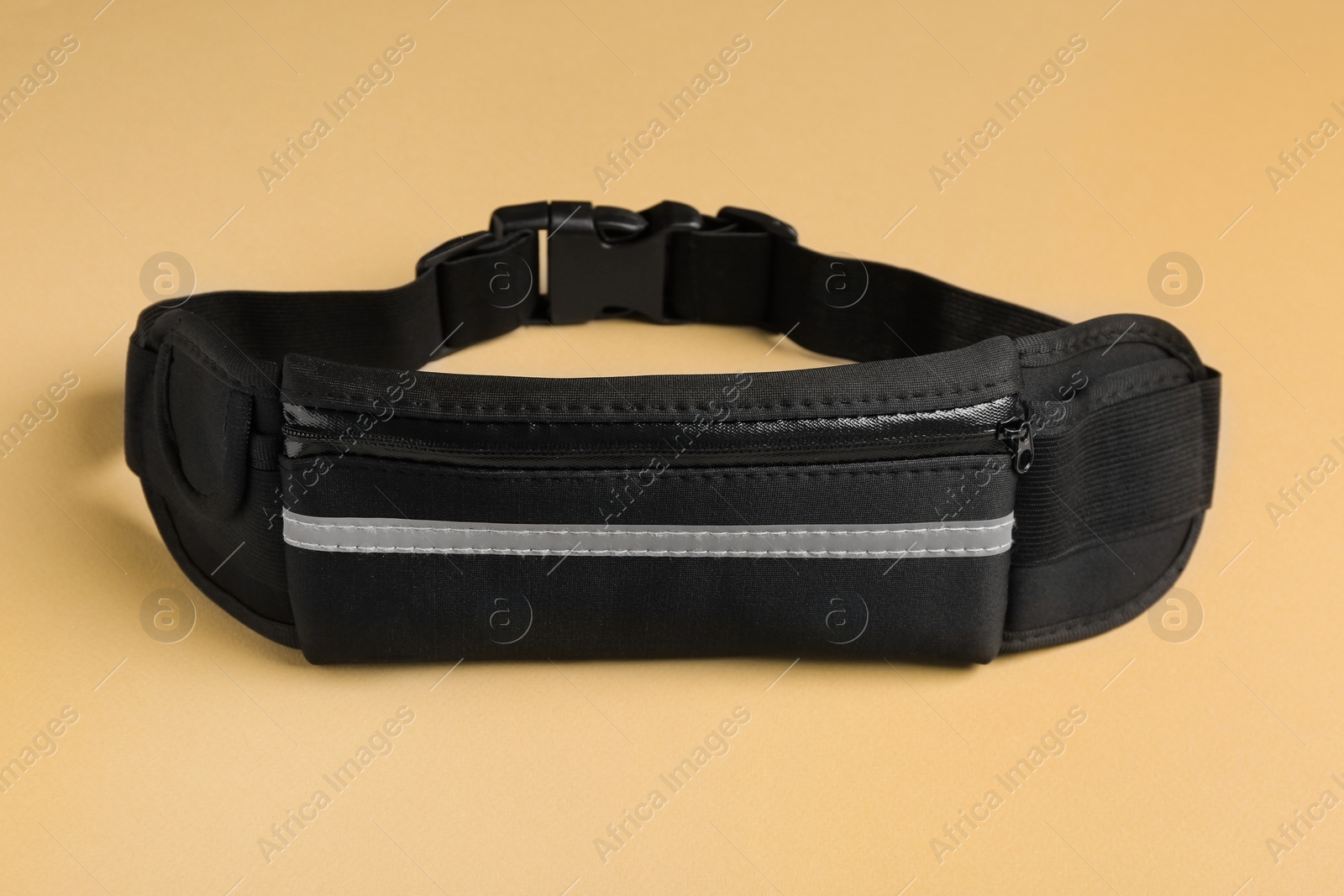 Photo of Stylish black waist bag on green background