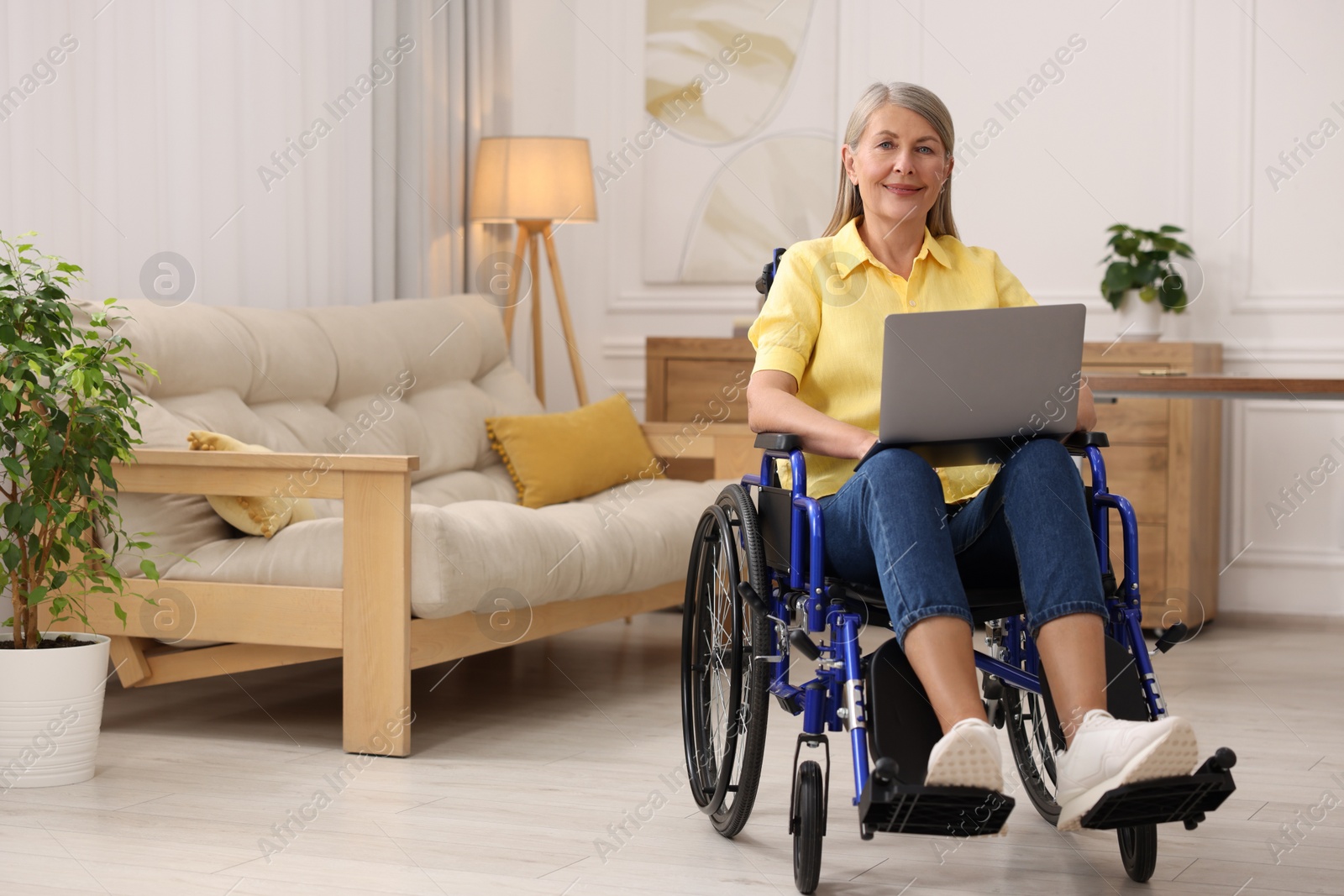 Photo of Woman in wheelchair using laptop at home