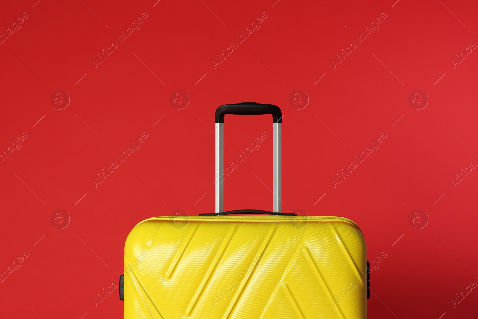 Photo of Stylish yellow suitcase with handle on color background