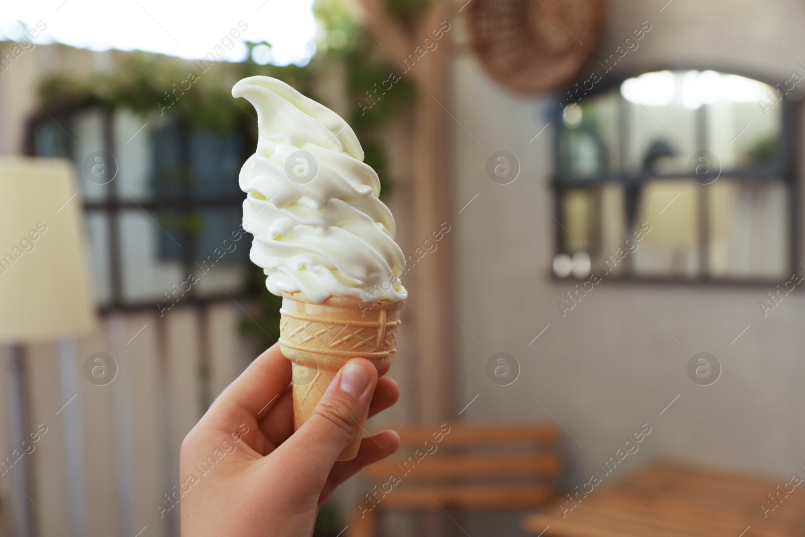 Photo of Woman holding delicious ice cream indoors, closeup. Space for text