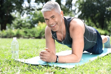 Photo of Handsome mature man doing exercise in park. Healthy lifestyle