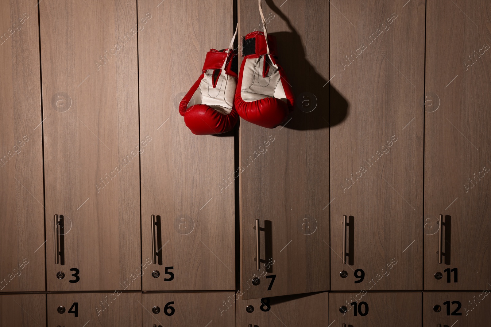 Photo of Red boxing gloves hanging on locker door in changing room