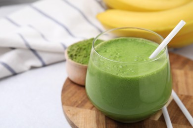 Photo of Glass of tasty matcha smoothie on white table, closeup. Space for text