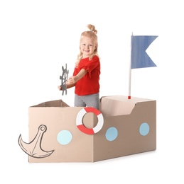 Cute little girl playing with cardboard ship on white background