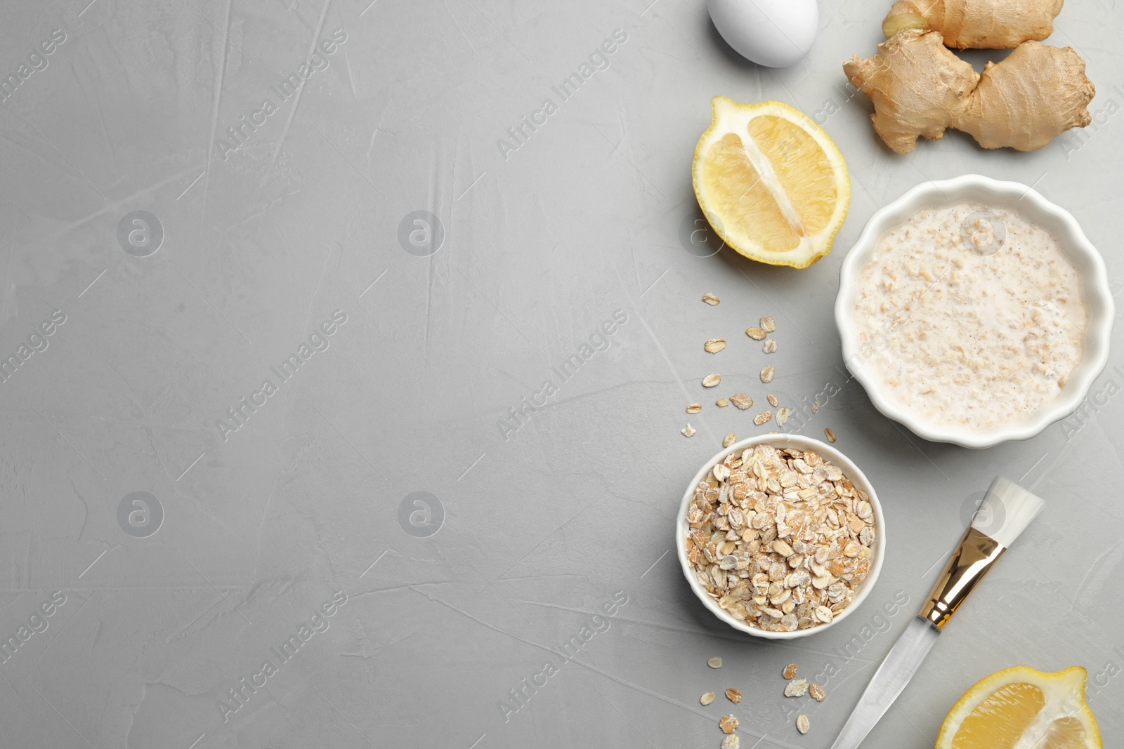 Photo of Different ingredients and handmade face mask on grey stone background, flat lay. Space for text