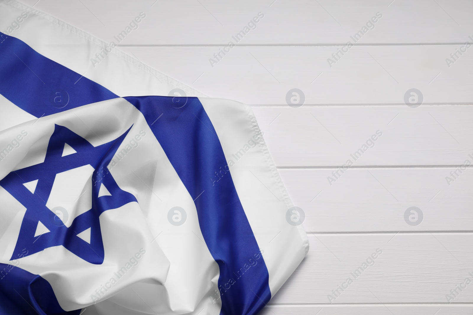 Photo of Flag of Israel on white wooden background, top view and space for text. National symbol