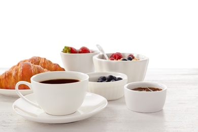 Delicious breakfast on wooden table against white background