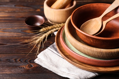 Photo of Different dishware on wooden table, closeup. Space for text