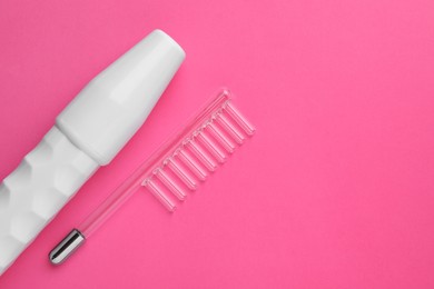 Photo of Modern darsonval with nozzle on pink background, flat lay. Space for text