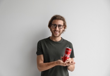 MYKOLAIV, UKRAINE - NOVEMBER 28, 2018: Young man with Coca-Cola can on white background