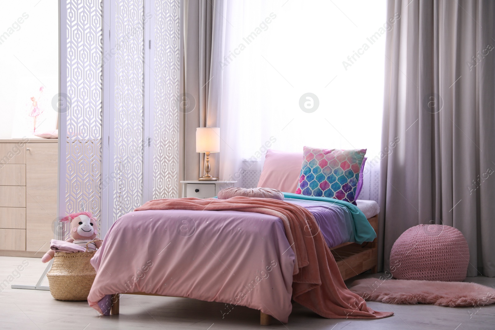 Photo of Bed with beautiful linens in children's room. Modern interior design